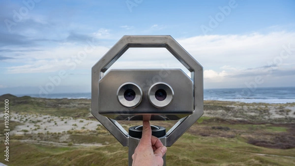 Obraz looking to the sea through binoculars positioned in the dunes