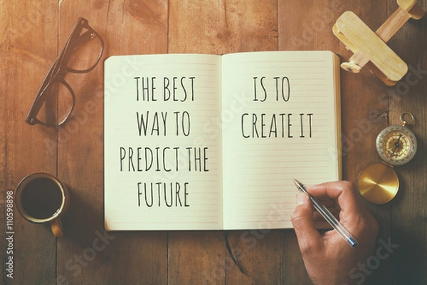 Obraz otwórz notatnik nad drewnianym stołem z motywacyjnym powiedzeniem