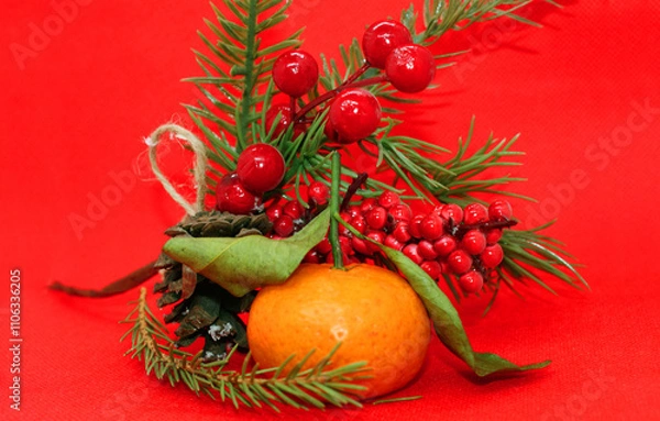 Fototapeta A spruce branch with a pine cone and a tangerine with leaves on a beautiful background, holiday, Christmas.