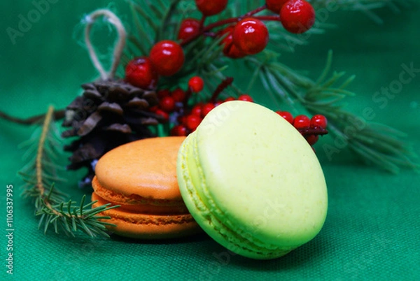 Fototapeta A spruce branch with a pine cone and multi-colored macaroons on a beautiful background, holiday, Christmas.