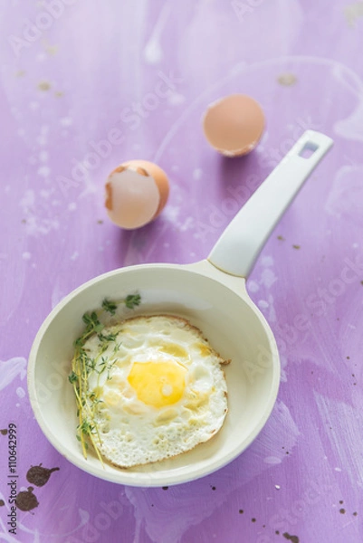 Fototapeta Fried eggs at lilac background