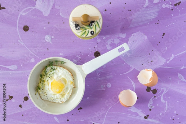 Fototapeta Fried eggs at lilac background