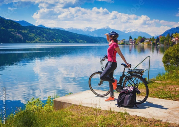 Obraz kobieta z e-bike, ciesząc się widokiem na jezioro