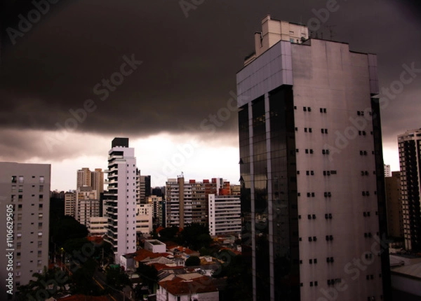 Obraz A storm brewing in the skies over São Paulo, Brazil. Dark clouds and lightning fill the sky, creating an intense, dramatic scene.