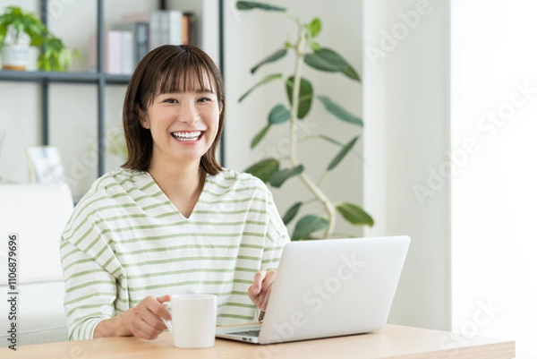 Fototapeta リビングでパソコンを使う若い女性