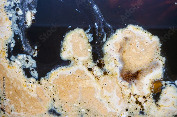 Obraz yellow abstract spots on black water.
