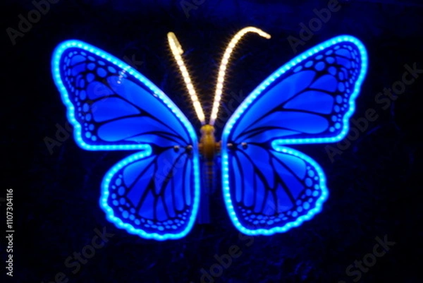 Fototapeta A beautifully illuminated butterfly sculpture featuring vibrant colors, perfect for adding charm to any indoor or outdoor space.