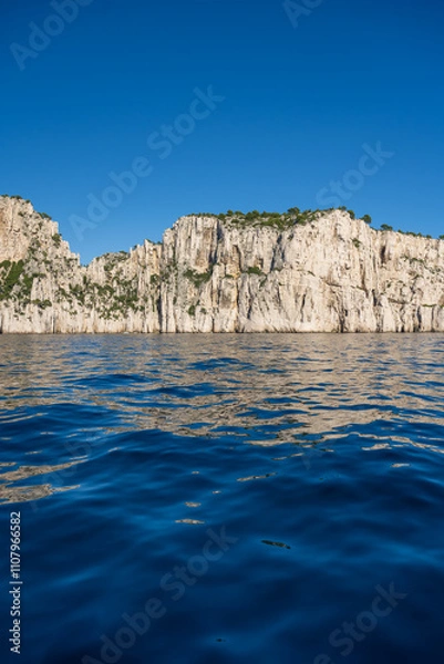 Fototapeta View from the Mediterranean Sea to the rocky coast of the Calanque National Park on a sunny summer day.