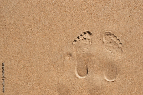Fototapeta Top view of footprints on sand with space for text