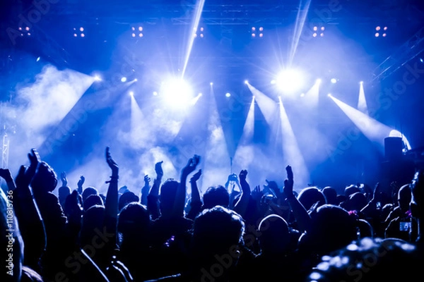 Fototapeta silhouettes of concert crowd in front of bright stage lights