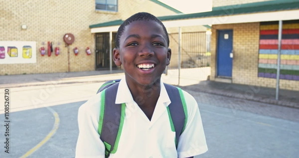 Obraz Portrait close up of a young African schoolboy wearing his school uniform and schoolbag, looking to