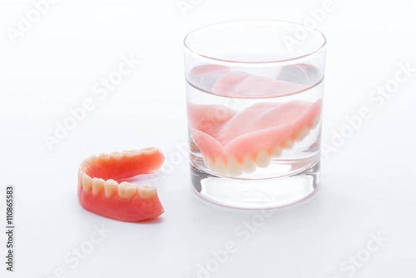 Obraz Full Denture in glass of water on white background