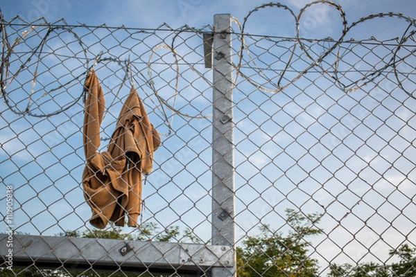 Obraz Clothes on razor wire fence