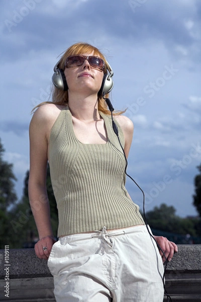 Fototapeta woman listening to music outdoor