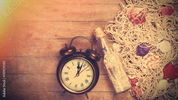 Fototapeta Retro alarm clock and net with shells and bottle