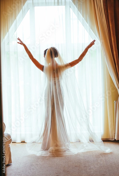 Fototapeta Portrait of the beautiful bride against a window indoors