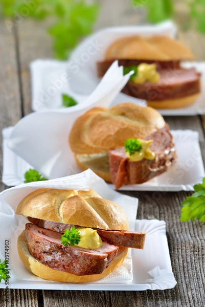 Fototapeta Street food bayerisch: Drei warme Leberkässemmeln mit Senf auf Papiertellern mit Serviette - Bavarian street food: Three rolls with meat loaf and mustard on paper plates  with white napkins