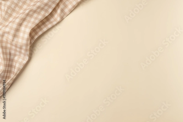 Fototapeta Checkered napkin on beige background. Flat lay, top view. Copy space