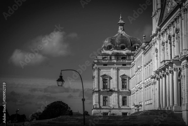 Obraz Dramatic black and white photo of the royal palace of mafra in portugal, with a vintage lamppost in front and intricate facade reaching towards the sky