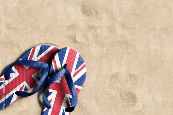 Fototapeta Thongs with flag of United Kingdom, on beach sand