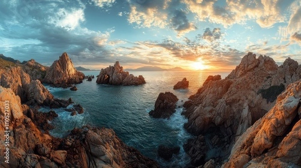 Fototapeta Colorful clouds reflect the setting sun over a rugged coastline, where large rock formations rise from the tranquil ocean. The scene captures a moment of natural beauty and serenity at dusk