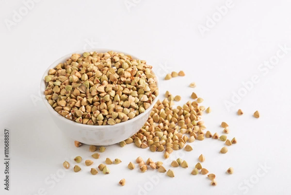 Fototapeta Dietary green buckwheat groats in a  white  bowl isolated on white background