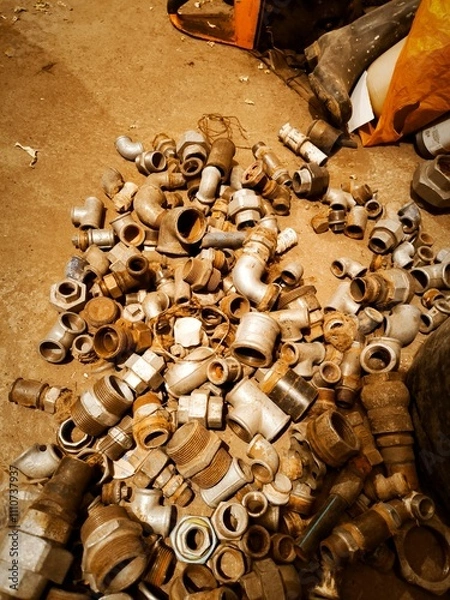 Fototapeta A creative mess of pipe fittings scattered across an old workshop, capturing the chaotic yet artistic atmosphere of craftsmanship and industrial work.