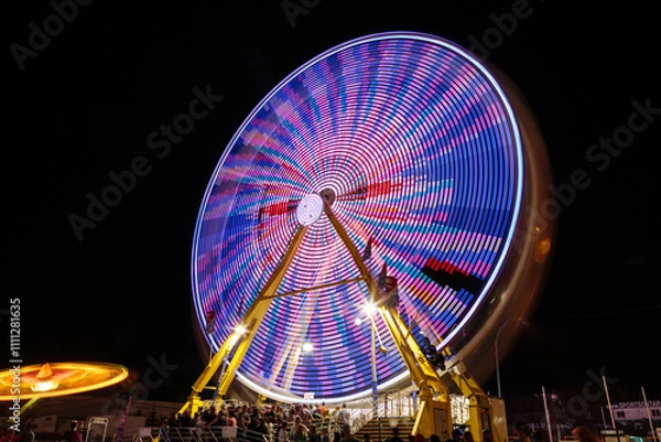 Fototapeta A colorful merry go round with people on it