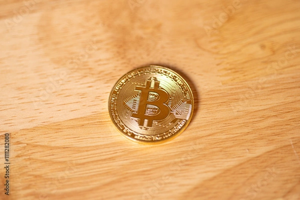 Fototapeta A physical Bitcoin on a wood surface