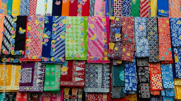 Fototapeta Colorful batik fabrics displayed in a market. Close-up shot highlights intricate patterns and vibrant colors. Perfect for fashion blogs or promoting Indonesian culture