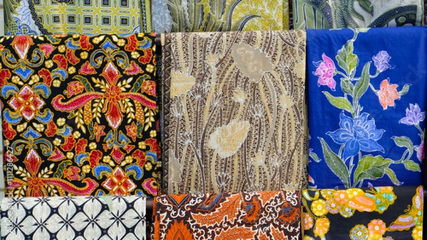 Fototapeta Colorful batik fabrics displayed in a market. Close-up shot highlights intricate patterns and vibrant colors. Perfect for fashion blogs or promoting Indonesian culture