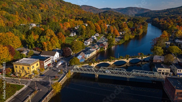 Fototapeta 10/12/22 SHEFFIELD FALLS, MA., USA - aerial view at sunrise of Sheffield Falls in autumn, Ma. with Housatonic River running through town, Berkshire Mountains