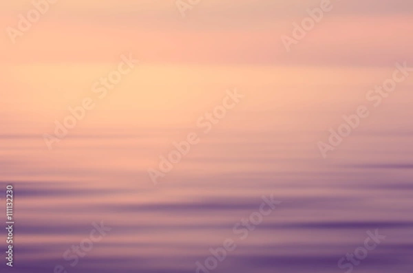 Fototapeta Blur tropical sunset beach with bokeh sun light wave abstract background. Travel concept.