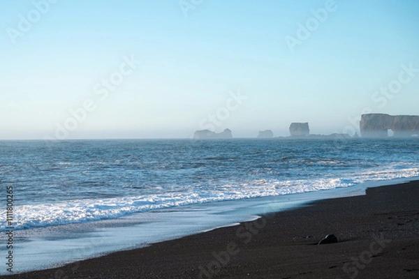 Fototapeta Reynisfjara black sand beach in Iceland. Ocean cliffs. Sunny day. Seascape. Touristic place.