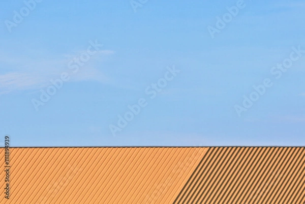 Fototapeta The front view shows only the roof of the building with a blue sky.