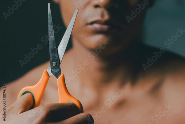 Obraz Man cutting paper with scissors, close-up