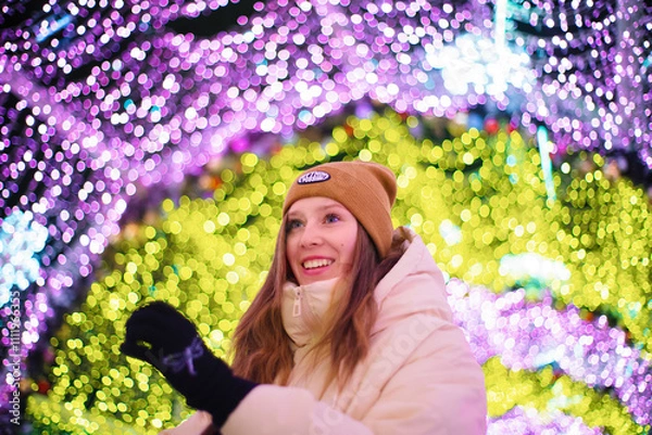 Obraz Young smiling happy girl in Christmas decorated with holiday lights. New Year's Eve, festive atmosphere