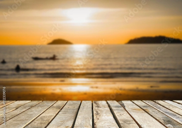 Fototapeta Wooden table top on blur sea.Before sunset concept.For montage product display or design key visual layout.View of copy space.