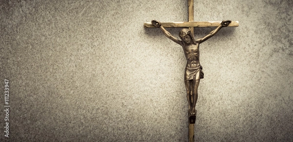 Fototapeta Krucyfiks Jezusa na krzyżu na kamiennym tle. Symbol chrześcijańskiej religii i wiary. Obraz składa się z miejsca na kopię.
