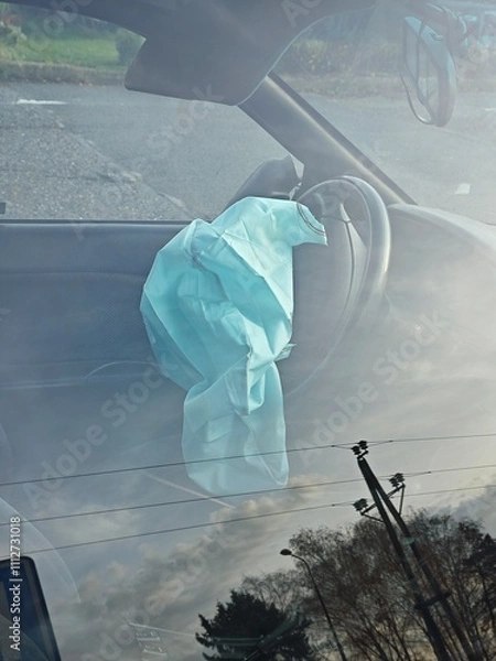 Fototapeta Deflated airbags after the erupted inflation due to a car collision. Car crash and airbag worked well. View through closed window. Broken rearview mirror