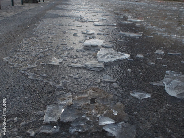 Fototapeta Shards of ice after flooding created black ice on the ground in Bonn, Germany