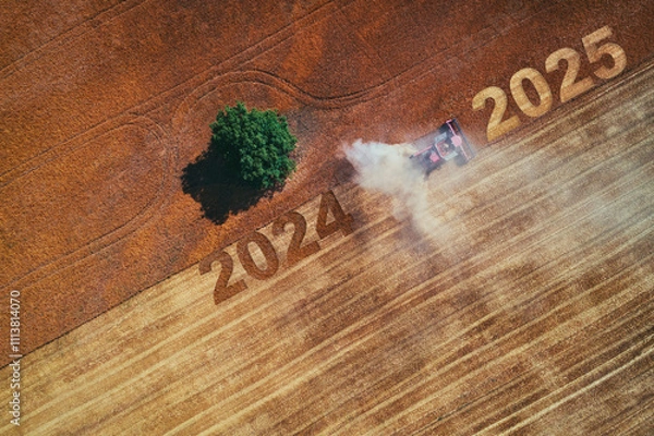 Fototapeta 2025 Happy new year concept of aerial view on the combine working on the large wheat field
