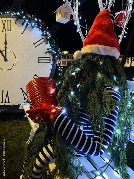 Fototapeta Christmas Elf Tree with Garland and Lights on a Bench