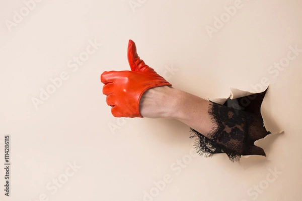 Obraz A woman's hand in a leather orange glove shows a gesture good
