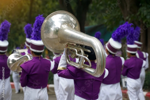 Obraz Students carry mellophones in the school orchestra procession It is a medium-pitched brass instrument used in marching bands and is used to play the French horn section in bands and orchestras.
