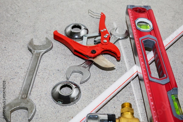 Fototapeta On the floor, there is a pair of metal wrenches and a pipe cutter
