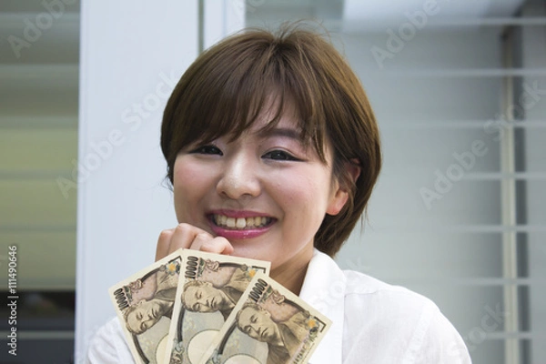 Obraz 3万円を持った笑顔の女性