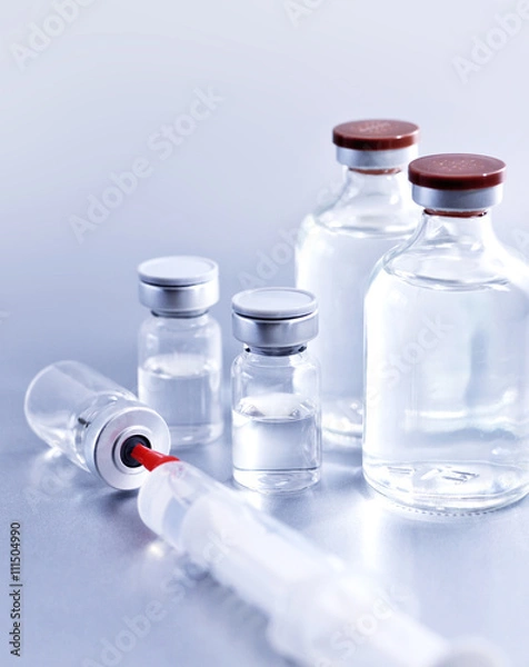 Fototapeta Vials and syringe, studio shot. Medical objects for vaccination. Vaccine drew up into a syringe.