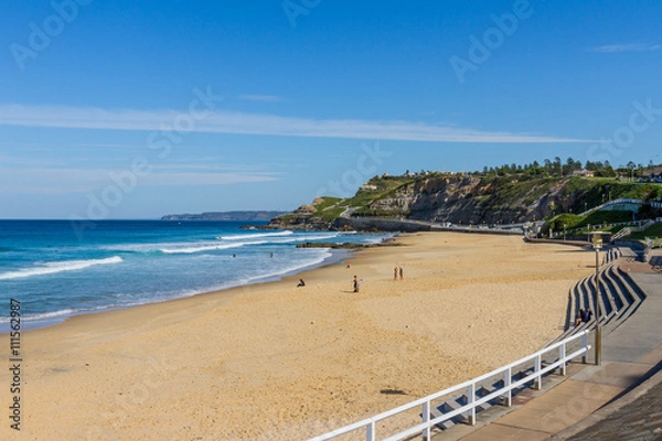 Fototapeta Newcastle Beach with cliffs in the background