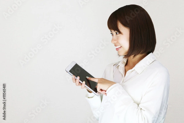 Fototapeta タブレットを操作する若い女性